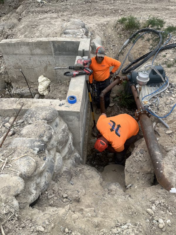 technicians working beside the concrete dam excavation (image 1)