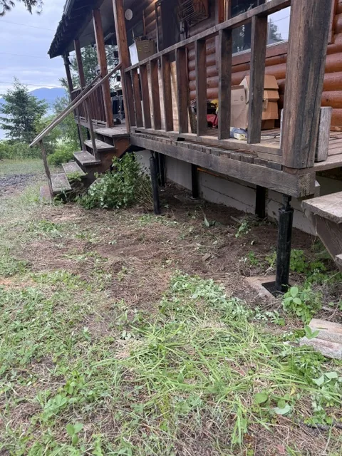 Adjustable screw jack posts supporting a log cabin porch