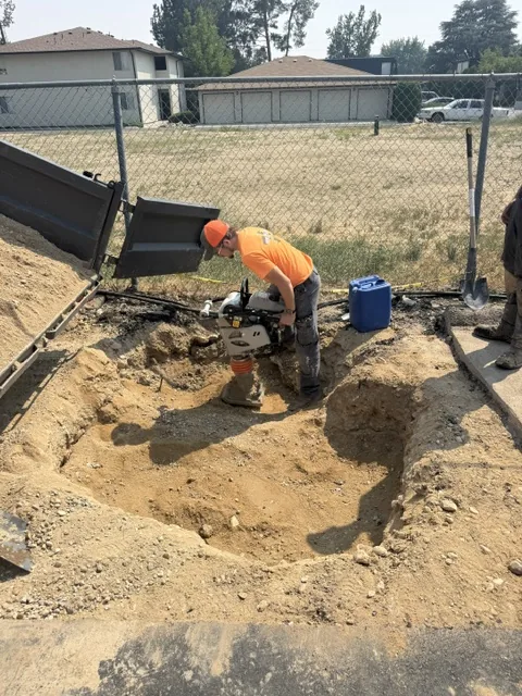 Soil being compacted with a rammer during sinkhole repair